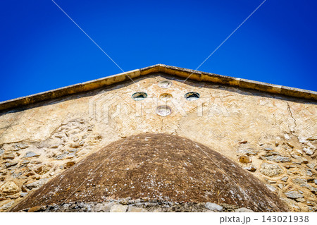 Ancient church roofline detail with stone wall, Crete, Greece Ancient church roofline detail with stone wall, Crete, Greece 143021938