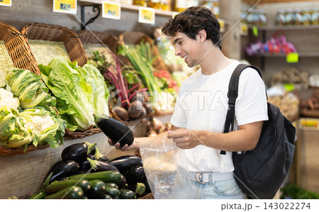 Adult man choosing eggplants at vegetable shop Adult man choosing eggplants at vegetable shop 143022274