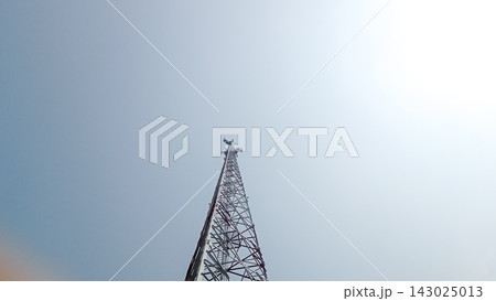 Low angle view of a tall telecommunication tower or network antenna structure reaching up into a clear blue sky, perfectly representing concepts like 5G connectivity, mobile network broadcasting, sate 143025013