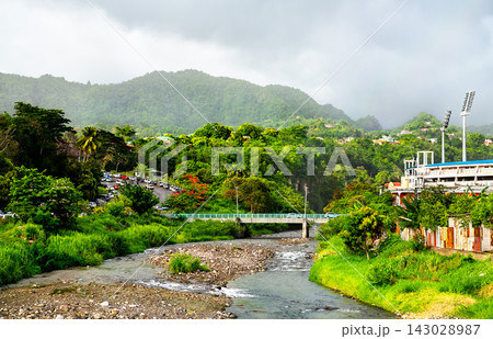 Scenic view of the Roseau River flowing through lush green hills toward Windsor Park Stadium in Roseau, Dominica. 143028987