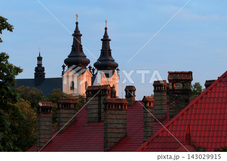 Europe architecture evening warm glow sunset time tower spire of church and roof top landmark soft colors lighting 143029915