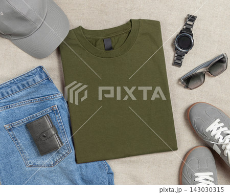 Blank military green folded t-shirt mockup, crewneck flat lay with denim jeans and mens accessories Blank military green folded t-shirt mockup, crewneck flat lay with denim jeans and mens accessories 143030315