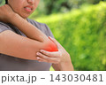 Close up unhappy Asian woman touching her elbow with a red highlighted area indicating severe joint pain, arthritis, muscle ache or sports injury. Healthcare, physical therapy, and medical concept. 143030481