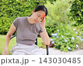 Unhappy Asian woman sitting on chair touching her head with red highlighted area indicating severe headache, migraine or brain pain. Concept of stress, sickness, healthcare, tension and mental health. 143030485
