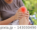 Close up of person sitting holding bare knee with red highlighted area indicating severe joint pain, arthritis, muscle ache or sports injury. Healthcare, physical therapy, medical orthopedic concept. 143030490