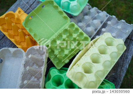 Eco friendly egg containers made of recycled paper pulp on wooden background Eco friendly egg containers made of recycled paper pulp on wooden background 143030560