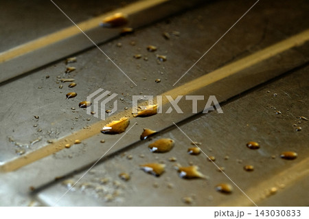 Drops of cooking fat oil liquid spilt on a stainless steel kitchen sink messy food preparation 143030833