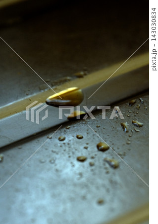 Drops of cooking fat oil liquid spilt on a stainless steel kitchen sink messy food preparation Drops of cooking fat oil liquid spilt on a stainless steel kitchen sink messy food preparation 143030834