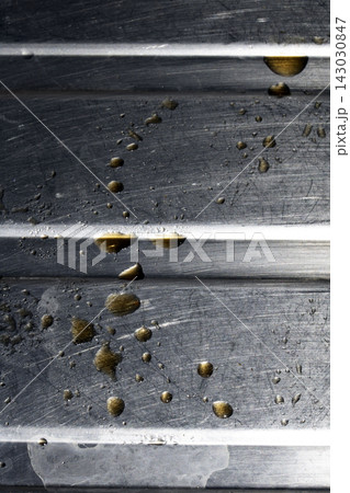 Drops of cooking fat oil liquid spilt on a stainless steel kitchen sink messy food preparation Drops of cooking fat oil liquid spilt on a stainless steel kitchen sink messy food preparation 143030847