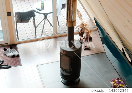 Modern wood stove inside a cozy wooden cabin during a bright day 143032545
