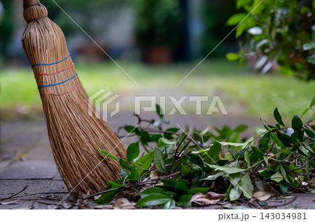 Straw Broom with Dry Leaves on Garden Path Straw Broom with Dry Leaves on Garden Path 143034981
