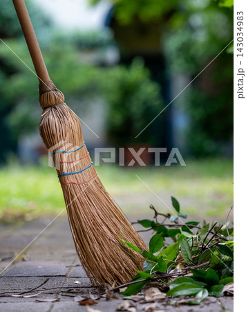 Straw Broom with Dry Leaves on Garden Path Straw Broom with Dry Leaves on Garden Path 143034983
