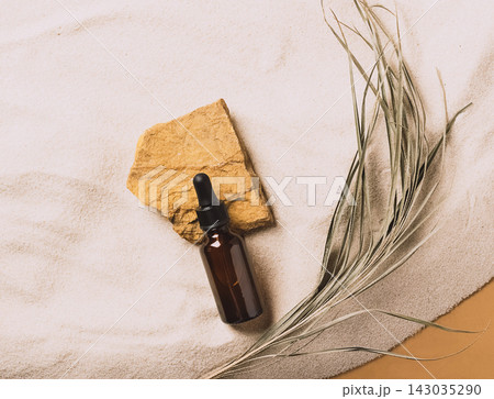Serum cosmetic bottle on sand background. Abstract podium natural materials product presentation sandy background.  143035290