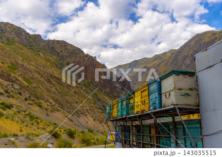 Colorful beehives on metal platform in mountainous landscape 143035515