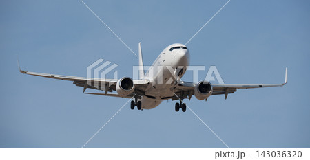 The plane lands. Airplane, passengers flying in the blue sky, preparing to land at the airport The plane lands. Airplane, passengers flying in the blue sky, preparing to land at the airport 143036320