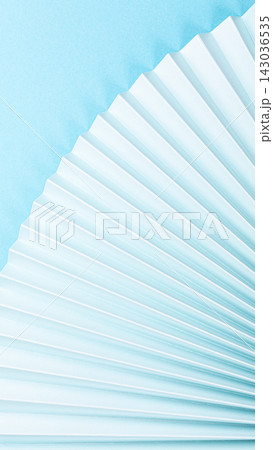 Elegant fan-shaped paper folds on a soft blue background showcasing texture and design elements 143036535