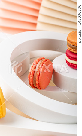 Colorful macarons arranged on a modern white display with soft pastel background elements Colorful macarons arranged on a modern white display with soft pastel background elements 143036536