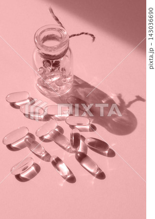 Pills and glass pill bottle on pink background. Big tablets. Omega 3 capsules. Close up, top view. Health care concept. Healthy every day fatty acids nutritional supplement dosage. Flat lay Pills and glass pill bottle on pink background. Big tablets. Omega 3 capsules. Close up, top view. Health care concept. Healthy every day fatty acids nutritional supplement dosage. Flat lay 143036690