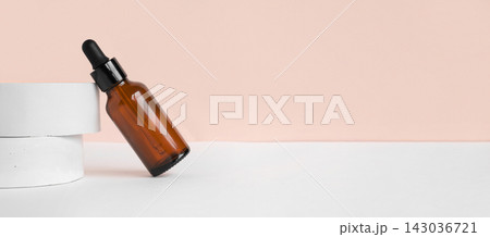 Amber glass dropper cosmetic bottle, white podium. Natural skin care SPA beauty product design. Mineral organic oil on beige background. Mock-Up. Oily pipette. Face and body treatment. Front view 143036721