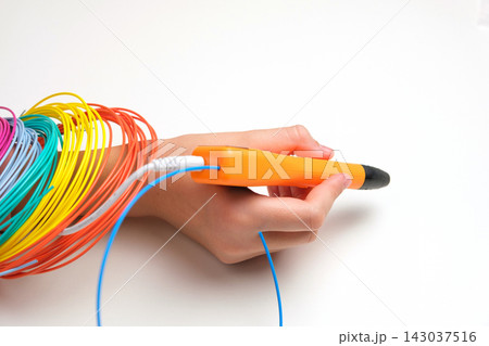 Teen Girl Using 3d Pen. Printing with Colored Plastic Wire Filament. Child making a House, drawing with 3D pen. Artwork, Robotics. STEAM, STEM education. Modern Technologies. Play and study at home Teen Girl Using 3d Pen. Printing with Colored Plastic Wire Filament. Child making a House, drawing with 3D pen. Artwork, Robotics. STEAM, STEM education. Modern Technologies. Play and study at home 143037516