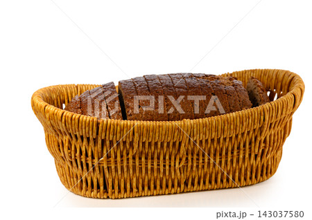 Commercial stock photo of a sliced artisan rye loaf neatly arranged within a wicker bread basket 143037580