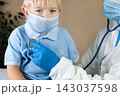 Medical examining boy in clinic. Little child checked by doctor. Pediatrician with stethoscope with face mask and toddler in a hospital. Check heart lungs of kid. Pediatric checkup in hospital 143037598