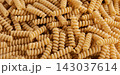 Gluten Free Cornmeal Pasta Wallpaper. Spiral Raw Macaroni from Corn and Rice flour rotating on Turntable. Close Up Top View. Uncooked Pasta Spinning. Full Frame. Food Background. Fusilli Bucati Corti 143037614