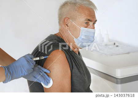 Doctor Vaccinating Senior Man In Clinic. Older People Vaccination. Doctor Giving Monkeypox or COVID Vaccine Injection to Mature Man In Face Mask. Protection of Elderly Patient. Old Man in Hospital 143037618
