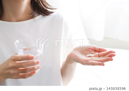 水と薬を手にする女性 水と薬を手にする女性 143038596
