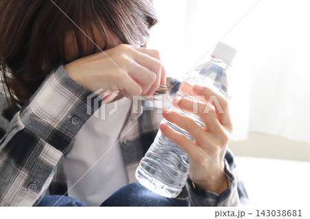 ペットボトルの水で水分補給をする女性 ペットボトルの水で水分補給をする女性 143038681