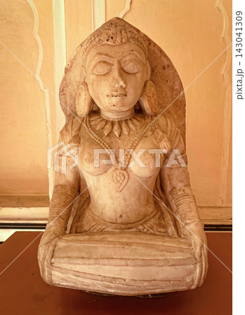 An ancient stone relief depicting Hindu deities. A detailed sculpture depicting Shiva with a third eye and Parvati seated nearby. 143041309