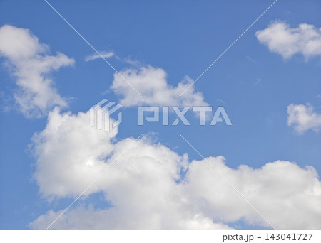 Fluffy White Clouds Floating in a Clear Blue Sky, Fresh and Peaceful Nature Background. Fluffy White Clouds Floating in a Clear Blue Sky, Fresh and Peaceful Nature Background. 143041727