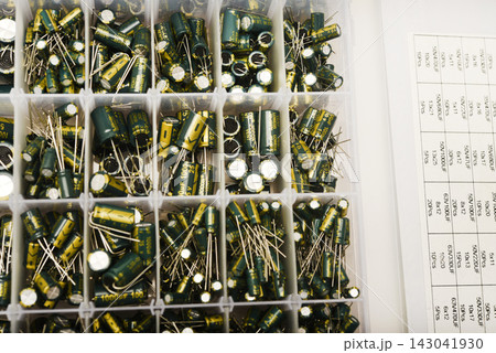 A set of capacitors. Green electrolytic capacitors in a box. Electronic components. Charge storage devices. 143041930