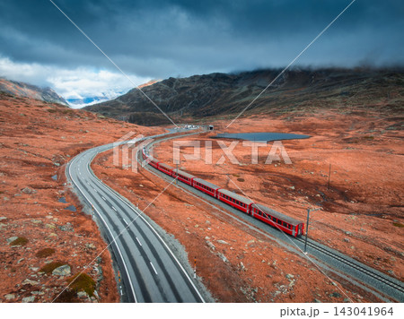 Aerial view of red train, river in mountains, road, orange forest Aerial view of red train, river in mountains, road, orange forest 143041964