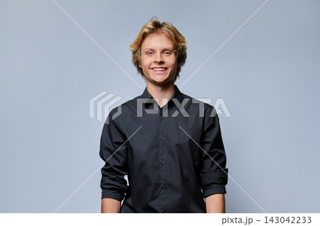 Smiling young man looking at camera in studio portrait 143042233