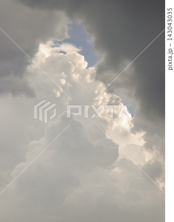 A dramatic, vertical vantage point capturing the awe-inspiring depth and grandeur of the atmosphere. Towering, sun-kissed cloud pillars ascend through a portal of dark, shadowy storm clouds, revealing A dramatic, vertical vantage point capturing the awe-inspiring depth and grandeur of the atmosphere. Towering, sun-kissed cloud pillars ascend through a portal of dark, shadowy storm clouds, revealing 143043035
