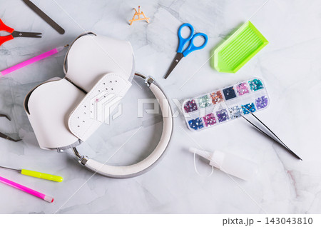 Headphones in a case and a set of colorful rhinestones for decoration on the table top view Headphones in a case and a set of colorful rhinestones for decoration on the table top view 143043810