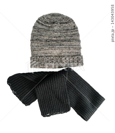 Warm winter clothes with knitted hat and scarf in snowy setting Warm winter clothes with knitted hat and scarf in snowy setting 143043958