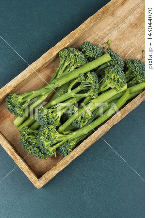 Raw broccolini in a rustic wooden box 143044070