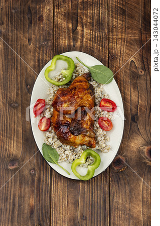 Grilled half chicken served with porridge. 143044072