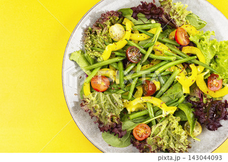 Colorful salad bowl with fresh greens and bean pods Colorful salad bowl with fresh greens and bean pods 143044093
