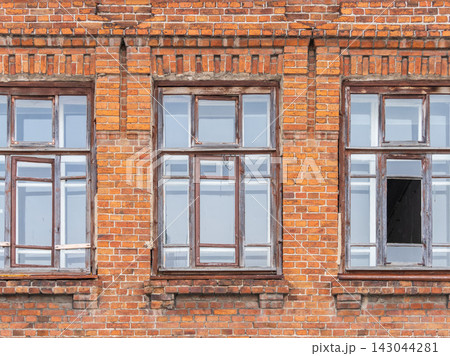 Three windows of the old mansion 19 century with brown bricks wall 143044281