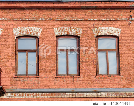 Three windows of the old mansion 19 century with brown bricks wall Three windows of the old mansion 19 century with brown bricks wall 143044491