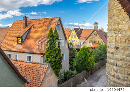 Rothenburg ob der Tauber, medieval old town in region of Bavaria in Germany, Europe. Charming Residential Rooftops and Historic Tower in a Sunny European Village Landscape 143044724