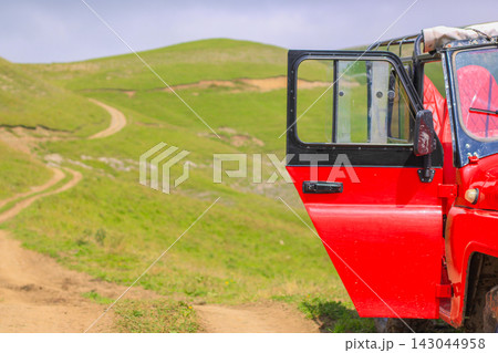 Mountain landscape viewed from above with red offroad car Mountain landscape viewed from above with red offroad car 143044958
