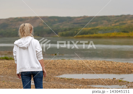 Woman at the river in wilderness is enjoying the autumn view. 143045151