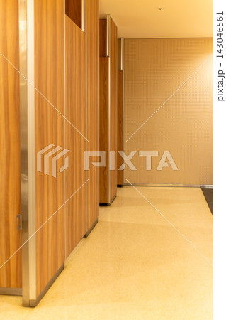 木目調の壁と白い小便器が並ぶモダンなトイレ空間 143046561