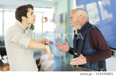 Upset senior man employee of company quits job, and guy manager shouts after him. 143049865