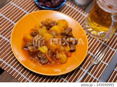 Stewed veal in sauce on a plate with vegetables Stewed veal in sauce on a plate with vegetables 143049995