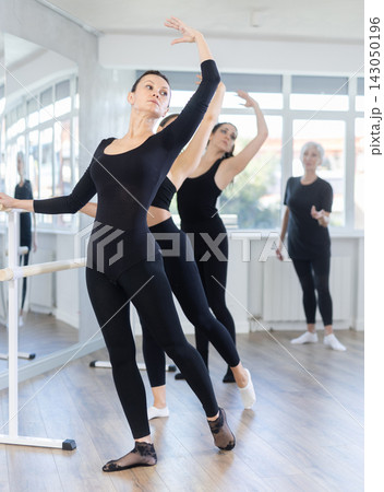 Graceful women of different ages practice at ballet stand in fifth position 143050196